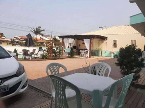 a table and chairs on a patio with a car at 01 - Casa Praia da Pinheira in Palhoça