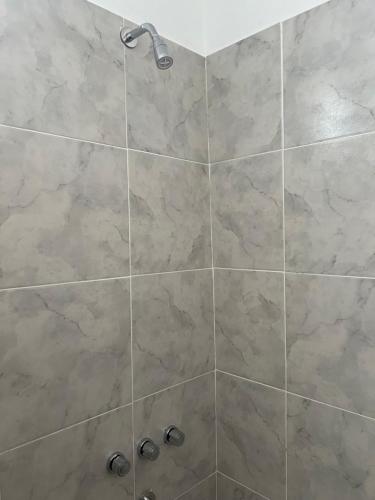a bathroom with a shower with a large stone tile wall at studios in Cordoba in Cordoba