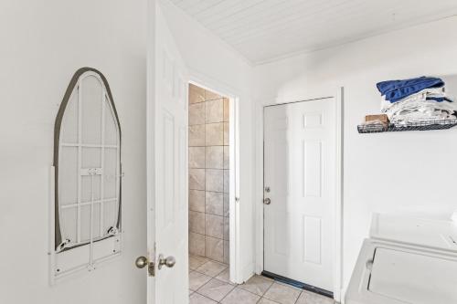 a white bathroom with a mirror and a sink at Charming 3-bedroom house in Wilmington with WiFi, AC in Wilmington