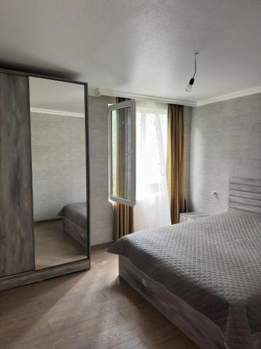 Un dormitorio con una cama y un espejo grande. en Villa Rachuli Sakhli, en Utsera