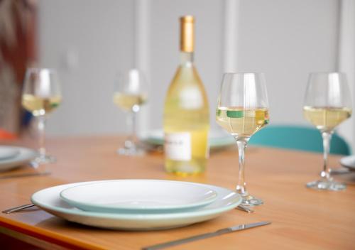 une table avec une assiette et deux verres de vin dans l'établissement DUPLEX 60m2 - MONTPELLIER PROCHE GARE, à Montpellier