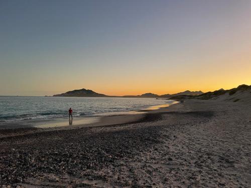 a person walking on the beach at sunset at Cabo Pulmo Beach Resort in Cabo Pulmo