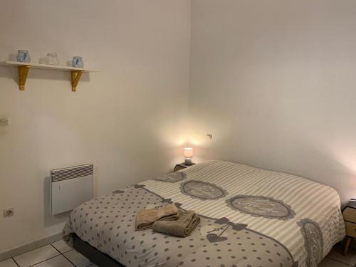 une chambre avec un lit avec une serviette dessus dans l'établissement Le patio, à Sète