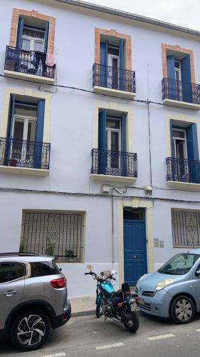 une moto garée dans un parking devant un bâtiment dans l'établissement Le patio, à Sète