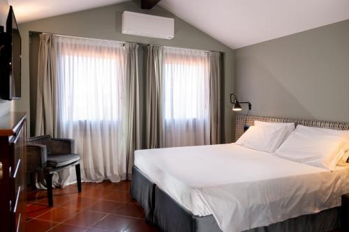 a bedroom with a large white bed and a chair at Hotel Tiziano in Venice