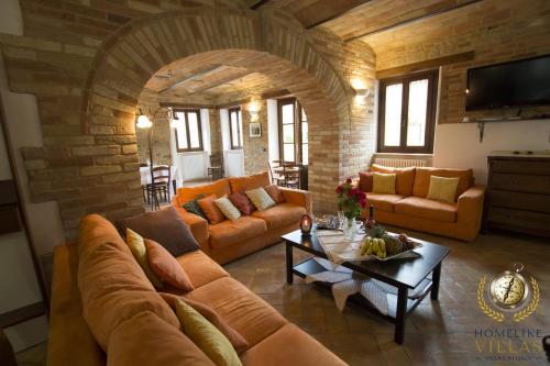 a living room with a couch and a table at Dreamy Brick Villa With Unbelievable View And A Pool in SantʼAngelo in Pontano