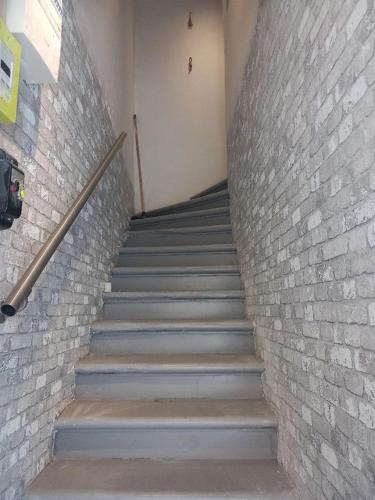 un escalier dans un bâtiment avec un mur en briques dans l'établissement Comme chez Soi, à Martigues