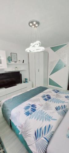 a bedroom with a bed and a chandelier at Apartman Kan in Bihać