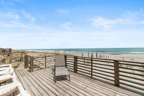 a wooden deck with a bench on the beach at Sunrise to Sunset Oceanfront Home with Creek Dock in Pawleys Island