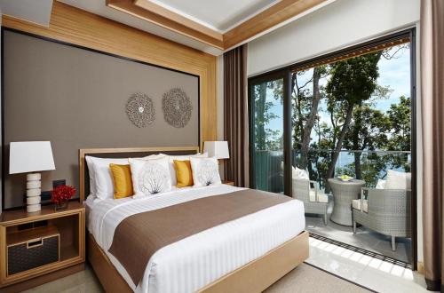 a bedroom with a large bed and a large window at Amari Phuket in Patong Beach
