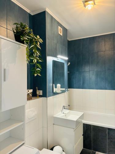 a bathroom with a sink and a toilet and a plant at One Apartments NordOne Iulius Town in Timişoara