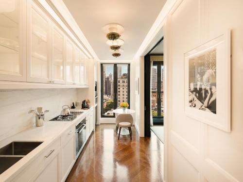 a kitchen with white cabinets and a large window at Fasano Fifth Avenue I Private Members Club & Hotel in New York