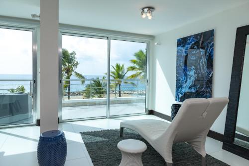a living room with white chairs and a view of the ocean at The Ocean Club, a Luxury Collection Resort, Costa Norte in Sosúa