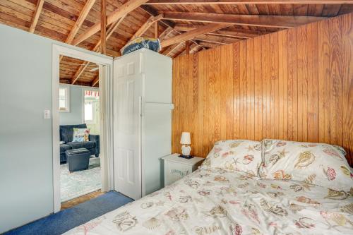 ein Schlafzimmer mit einem Bett und Holzwänden in der Unterkunft Rockport Cottage with Patio - Steps to Beach! in Rockport