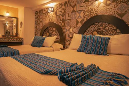 a hotel room with two beds and a mirror at Hotel Tepeyac in San Cristóbal de Las Casas