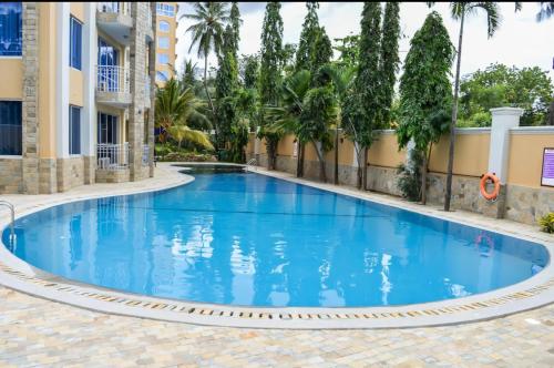 a swimming pool in a resort with blue water at Beachfront Luxurious Apartment in Mombasa