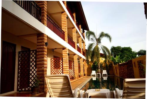 a balcony of a house with chairs and a palm tree at Hathai House in Lamai
