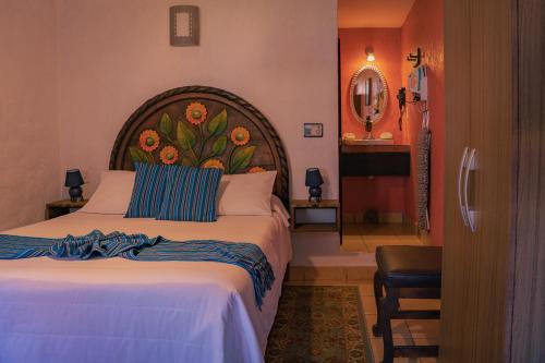 a bedroom with a large bed and a mirror at Hotel Tepeyac in San Cristóbal de Las Casas