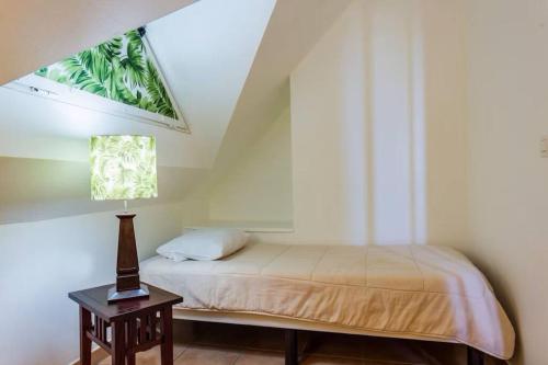 a bedroom with a bed and a lamp on a table at NEW ! 3 pièces avec piscine et plage accessibles à pieds in Sainte-Luce