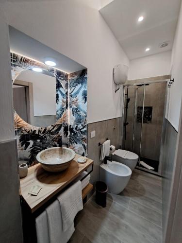 a bathroom with two sinks and a toilet and a shower at I Catusi GuestHouse in Santo Stefano di Camastra