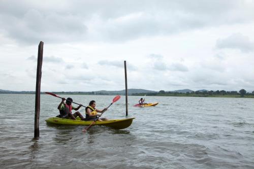 a group of people in kayaks in the water at Waterwoods Lodge Kabini in Begūr
