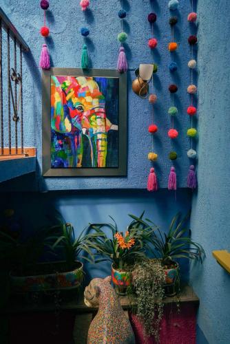 a painting of an elephant on a blue wall with pins at Hotel Tepeyac in San Cristóbal de Las Casas