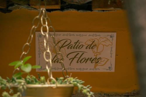 a sign on a wall with a potted plant at Hotel Tepeyac in San Cristóbal de Las Casas