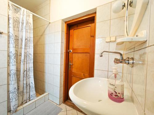 a bathroom with a sink and a shower curtain at Pokoje gościnne u Stocha in Poronin