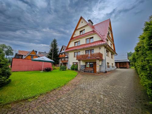 a large white house with a red roof at U Stocha - Jacuzzi & sauna - dom dla 13 osób in Poronin