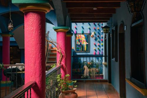 a room with pink columns and a wall with a painting at Hotel Tepeyac in San Cristóbal de Las Casas