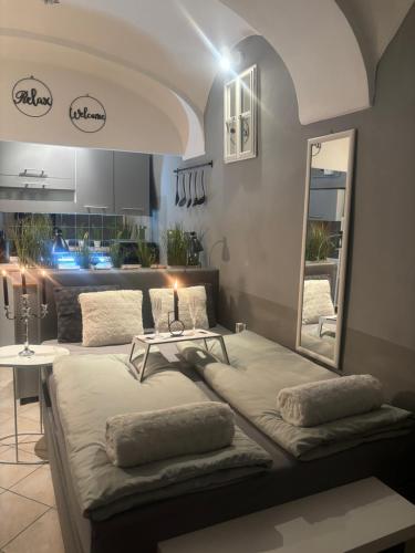 two beds in a room with a mirror and a kitchen at Studio Old Town in Maribor