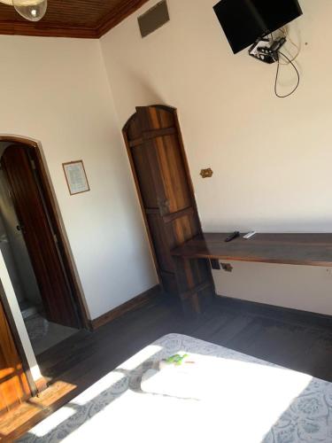 a bedroom with a bed and a wooden cabinet at Solar Colonial Pousada in Iguape