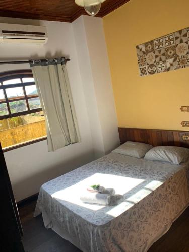 a bedroom with a bed with a towel on it at Solar Colonial Pousada in Iguape