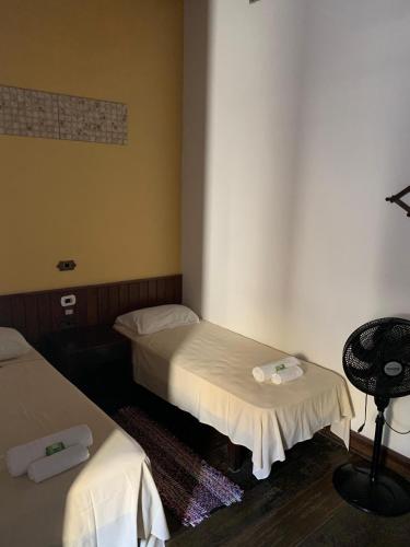 a room with two beds and a chair in it at Solar Colonial Pousada in Iguape