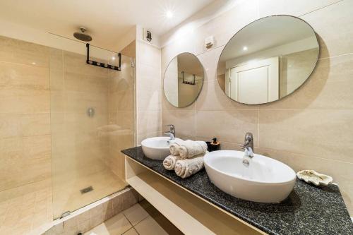Un baño con dos lavabos y un espejo grande. en La Rose Bohème Boucan Canot 2mn de la plage, en Saint-Paul