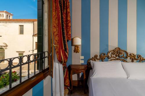 a bedroom with a bed and a balcony at Hotel Tiziano in Venice