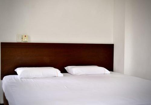a large bed with two white pillows on it at Magnifica finca santa fe de Antioquia in Santa Fe de Antioquia