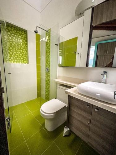 a bathroom with a toilet and a sink and a mirror at Magnifica finca santa fe de Antioquia in Santa Fe de Antioquia