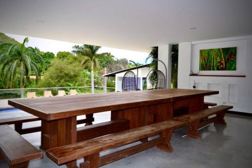 a large wooden table and benches on a patio at Magnifica finca santa fe de Antioquia in Santa Fe de Antioquia