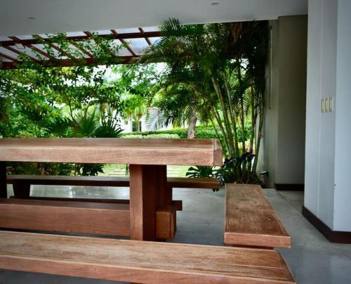 two wooden benches sitting in a room with trees at Magnifica finca santa fe de Antioquia in Santa Fe de Antioquia