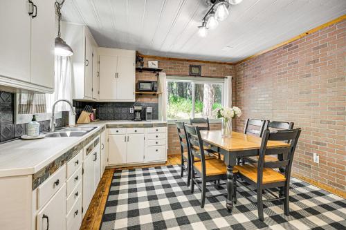 a kitchen with a table and chairs and a brick wall at Walk to Winery Cozy Cabin with Fire Pit in Murphys in Murphys