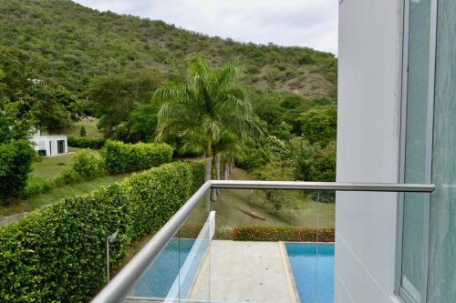 a view from the balcony of a house with a swimming pool at Magnifica finca santa fe de Antioquia in Santa Fe de Antioquia