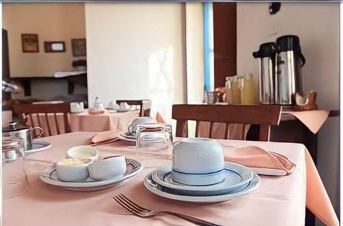 a table with a blue hat and plates on it at Solar Colonial Pousada in Iguape