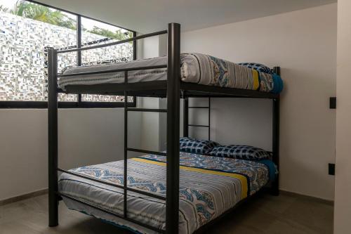 two bunk beds in a room with a window at Acapulco Retreat with Bay Views & Amenities in Acapulco