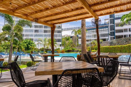 a patio with tables and chairs and a pool at Acapulco Retreat with Bay Views & Amenities in Acapulco