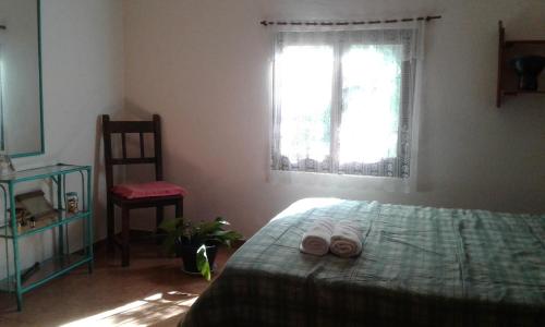 a bedroom with a bed with two towels on it at Habitacion serrana Stella Maris in Río Ceballos