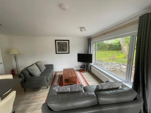 a living room with a couch and a table at Matara House Holiday Home in Inverness