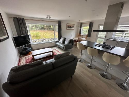 a living room with a couch and a table at Matara House Holiday Home in Inverness