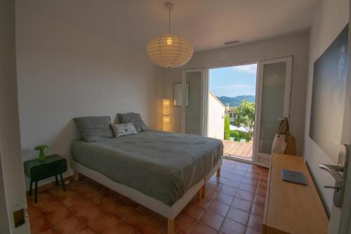 une chambre avec un lit et une grande fenêtre dans l'établissement Villa Le Soleil Bleu - Piscine - Jardin, à Le Tignet