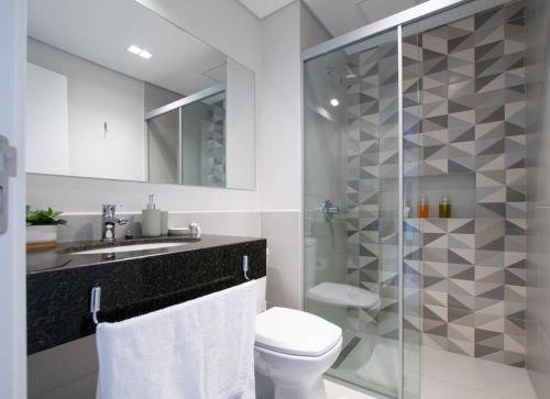 a bathroom with a toilet and a glass shower at Stylish 2BR Apt in Top Location in Asunción